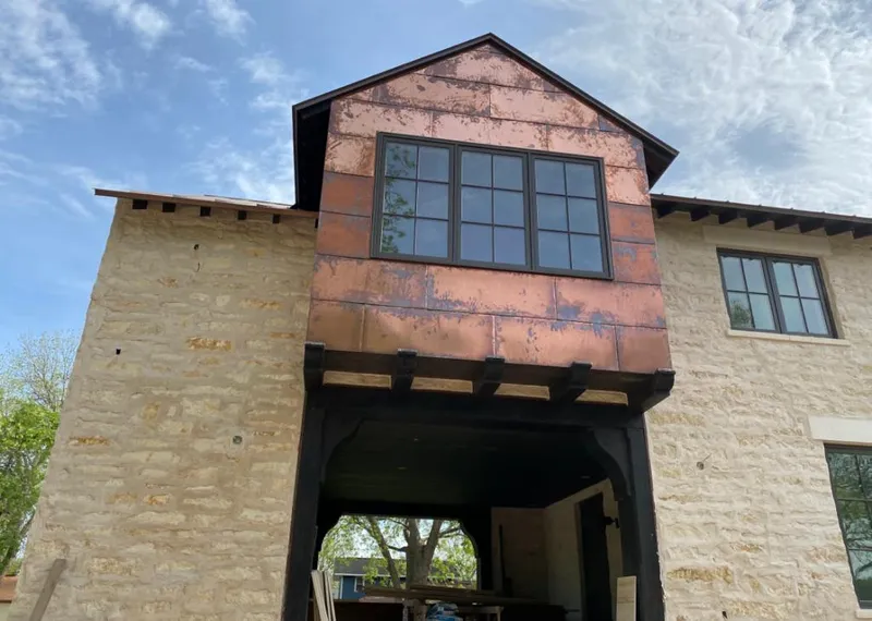 Copper metal panel facade on a stone building for Roof Repair in Cuero